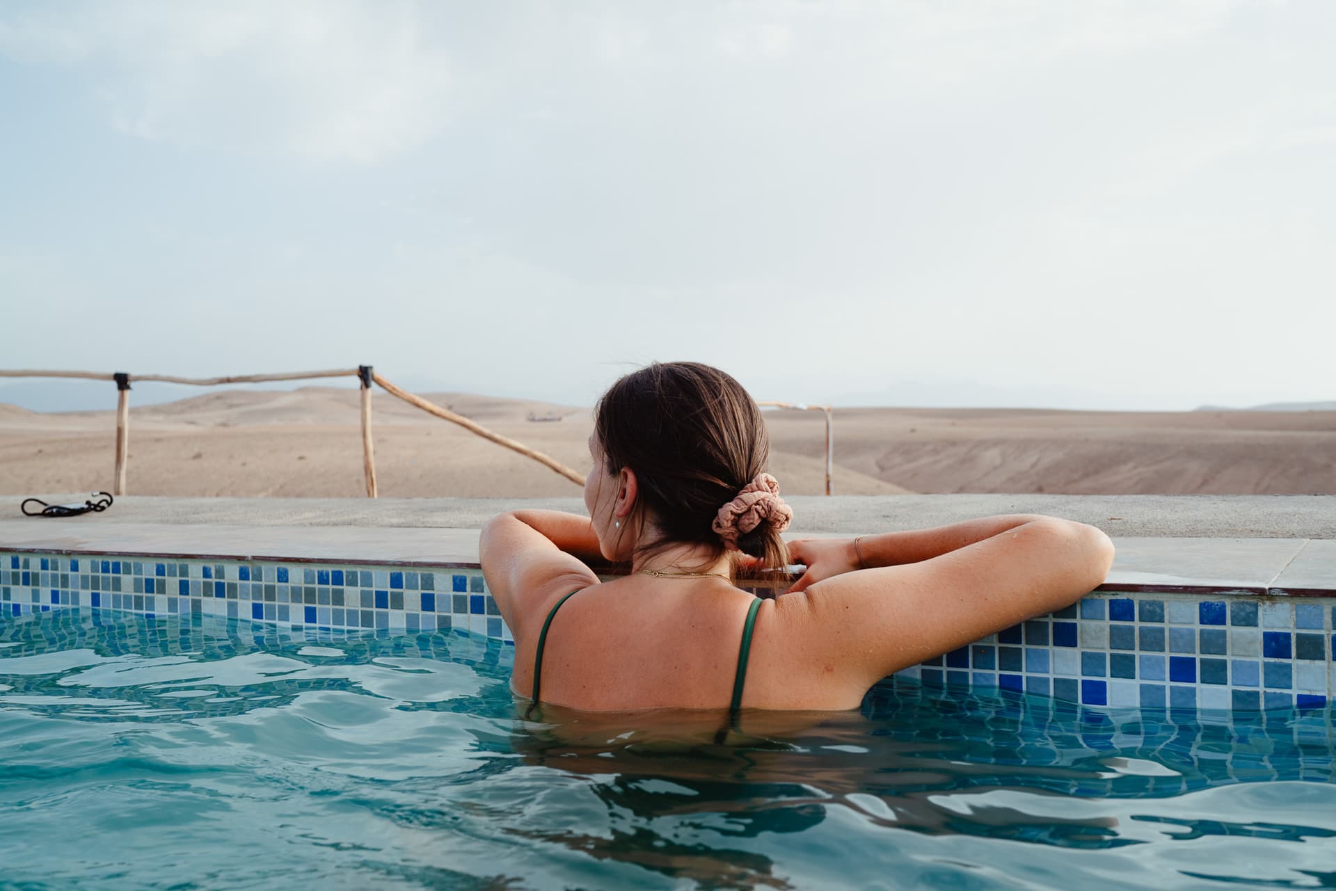 Frau entspannt sich im Pool und guckt in die Ferne